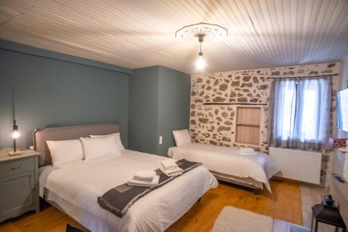 a bedroom with two beds and a window at το σπίτι του δάσκαλου- teacher's house in Sirako
