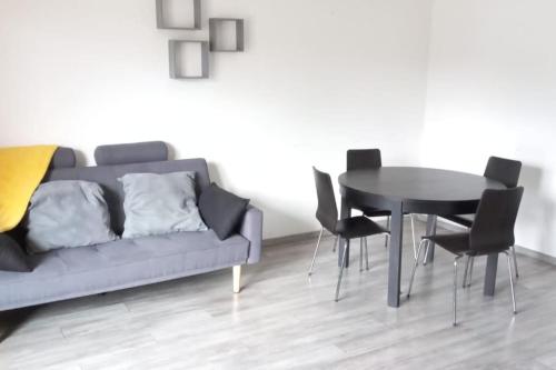 un salon avec un canapé, une table et des chaises dans l'établissement Corniche D'Azur 2 YourHostHelper, à Fréjus