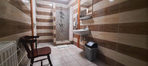 a small bathroom with a sink and a chair at Torony Lovarda Magánszállás in Kiskunfélegyháza