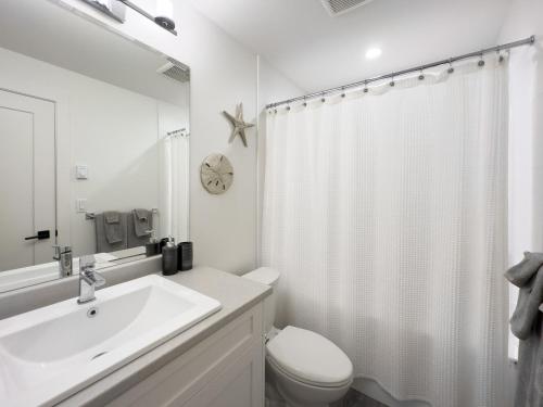 a white bathroom with a sink and a toilet at New 1 bed, 1 bath king suite 3 min from beach in Surrey