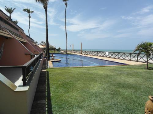 a house with a swimming pool next to the ocean at Cumbuco Ocean View in Cumbuco