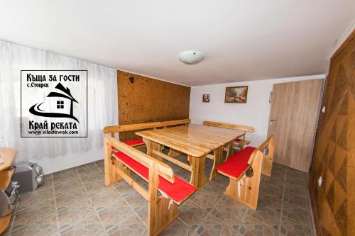- une salle à manger avec une table et des chaises en bois dans l'établissement Guest House By The River, à Stevrek