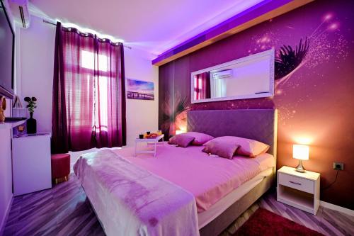 Dormitorio púrpura con cama grande con almohadas rosas en Luxury Apartment Laura, en Zadar