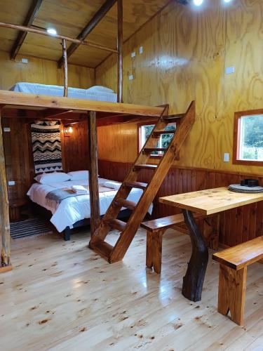 een kamer met een stapelbed en een bureau en een bed bij Cumbres del poicas in Cochamó