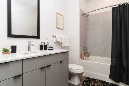 a bathroom with a sink and a toilet and a tub at MG Cozy Studio Fast Wi-Fi WFH Equipped in Morton Grove