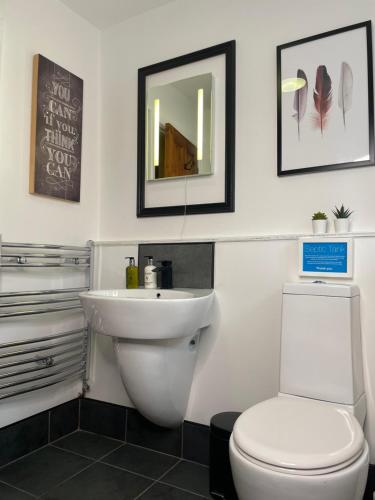 a bathroom with a white toilet and a sink at Mia Cottage in Keighley