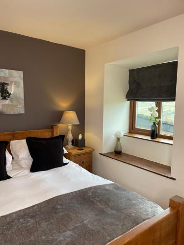 a bedroom with a large bed and a window at Mia Cottage in Keighley