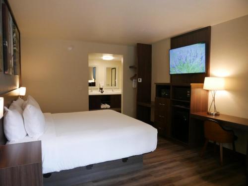 a hotel room with a bed and a flat screen tv at Days Inn by Wyndham Prescott in Prescott