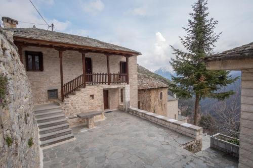 a stone building with a porch and a bench at το σπίτι του δάσκαλου- teacher's house in Sirako
