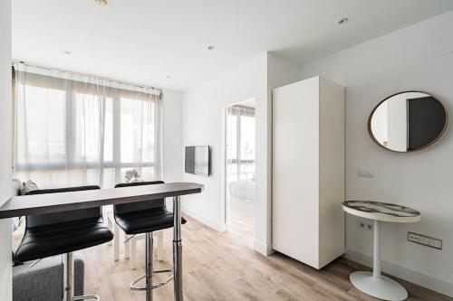 a dining room with a table and chairs and a mirror at Precioso apartamento en el Barrio Salamanca P A D in Madrid