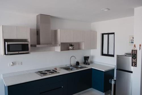 a kitchen with blue cabinets and a refrigerator at Departamento Vista Nova Culiacán in Casas