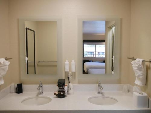 La salle de bains est pourvue de 2 lavabos et d'un grand miroir. dans l'établissement Days Inn by Wyndham Prescott, à Prescott