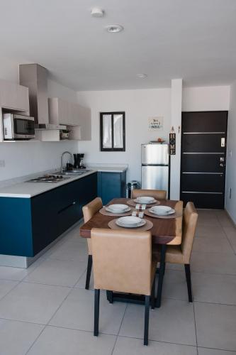 a kitchen with a wooden table and chairs in a kitchen at Departamento Vista Nova Culiacán in Casas