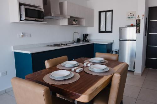 a kitchen with a wooden table with plates on it at Departamento Vista Nova Culiacán in Casas