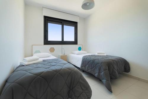 a bedroom with two beds and a window at Premium Apartment with Swimming pool by Aparters in Arenales del Sol