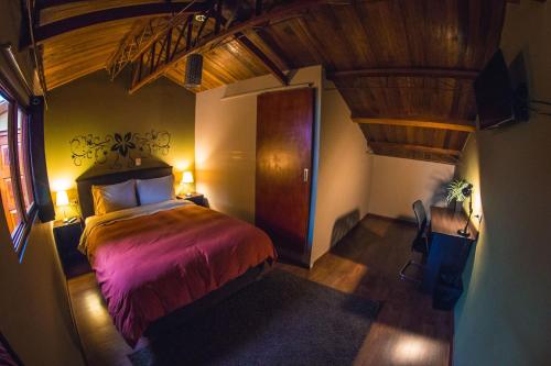 um quarto com uma cama e uma porta de madeira em Wild Rover Cusco em Cusco