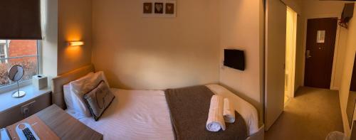 281 Hotel & Restaurant في مانسفيلد: غرفة نوم صغيرة بها سرير ونافذة