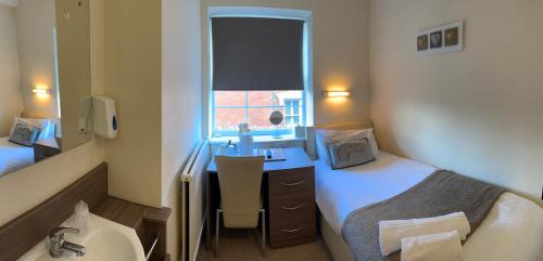 a bedroom with a bed and a desk and a sink at 281 Hotel & Restaurant in Mansfield