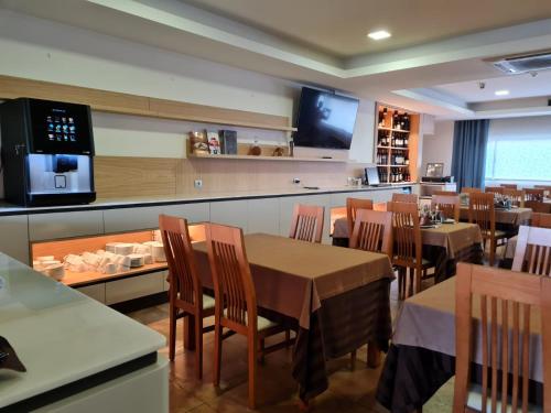 un restaurante con mesas y sillas y TV en Hotel Albergaria Borges, en Chaves