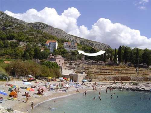a beach scene with people on the beach at Apartments Marija Magdalena in Hvar