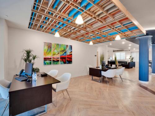 an office with tables and chairs and a painting on the wall at WaterWalk Extended Stay Raleigh Durham Research Triangle in Durham