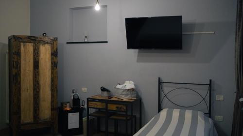 1 dormitorio con 1 cama y TV en la pared en Piccolo Borgo en Chiavari