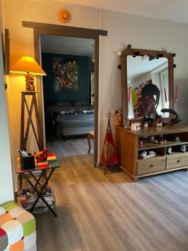 ein Wohnzimmer mit einem Spiegel und einem Bett in der Unterkunft Agréable maison de ville à Pacy sur eure in Pacy-sur-Eure