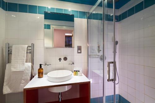 een badkamer met een wastafel en een douche bij London Paddington Apartments in Londen