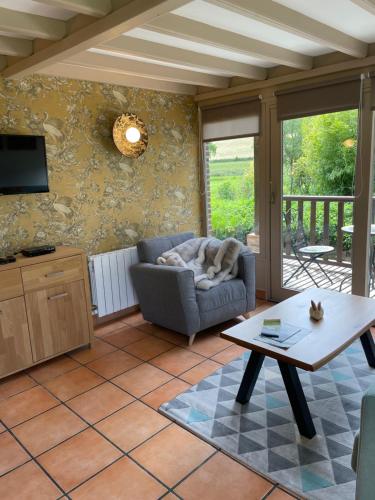 ein Wohnzimmer mit einem Sofa und einem Tisch in der Unterkunft Gîte du « Lavoir » à 2 pas de la mer in Saint-Martin-le-Gaillard