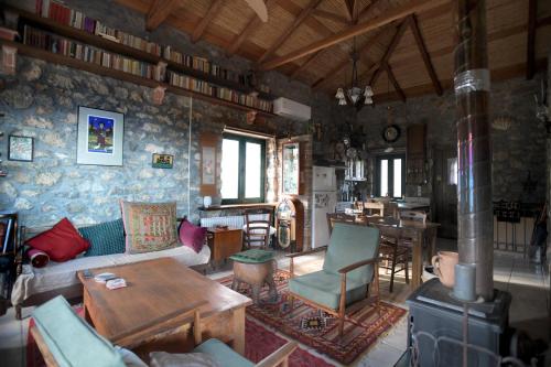 a living room with a couch and a table at Stone house with panoramic view in Tiros