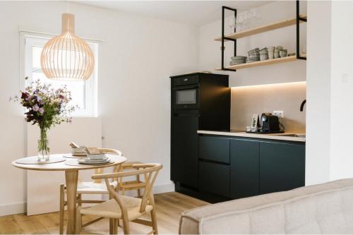 a kitchen and dining room with a small table and chairs at Brut the lodges in Reijmerstok
