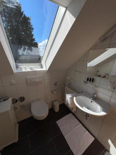 a bathroom with a sink and a toilet and a window at Sonniges Jura Loft im Golf Paradies Hilzhofen in Pilsach