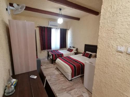 ein Hotelzimmer mit 2 Betten und einem Tisch in der Unterkunft Matan Rural Lodge in Tufailah