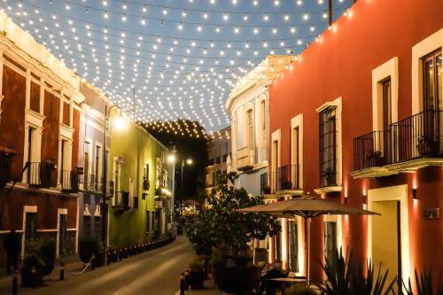 a street with lights and buildings and an umbrella at Cartesiano Boutique & Wellness Hotel in Puebla