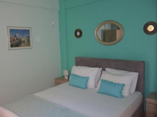 a bedroom with a bed with blue walls and a mirror at Katerina's Apartment in Toroni