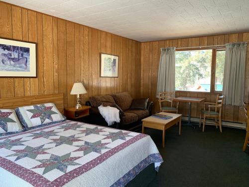 1 dormitorio con cama, sofá y mesa en Tete Jaune Lodge, en Tete Jaune Cache