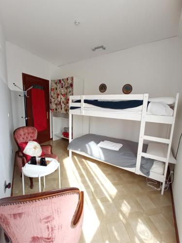 - une chambre avec des lits superposés, une chaise et une table dans l'établissement Casa Doretta - Camere Rooms, à Vérone