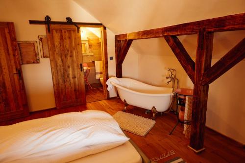 a bedroom with a bath tub and a bed in it at Slovenska Koliba 194 in Mădăraş