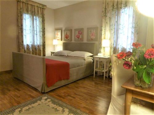 a bedroom with a bed and a table and flowers at La Casa del Giardiniere in Zero Branco