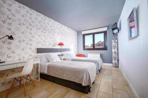 a bedroom with two beds and a desk at Apartahotel Comforsuite in Boecillo
