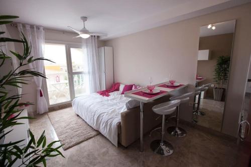 a bedroom with a bed and a table and a desk at Beau studio meublé avec vue mer in Almerimar