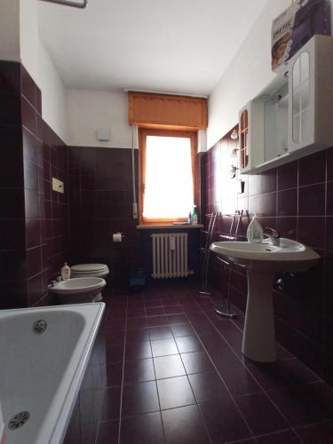 La salle de bains est pourvue de 2 lavabos, d'une baignoire et de 2 toilettes. dans l'établissement Casa Doretta - Camere Rooms, à Vérone
