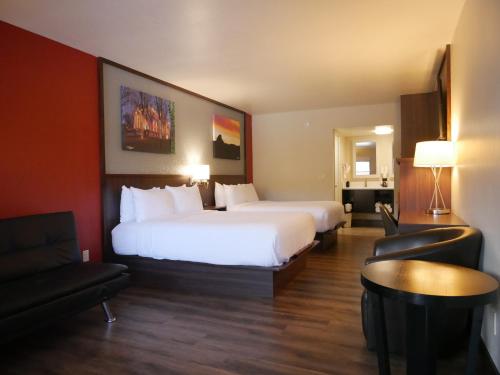 a hotel room with a large bed and a couch at Days Inn by Wyndham Prescott in Prescott