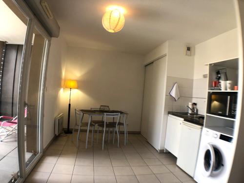 una pequeña cocina con mesa y microondas en La Robine - Studio 2 personnes avec parking, en Narbona