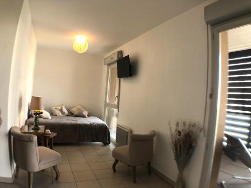 a bedroom with a bed and a table and chairs at La Robine - Studio 2 personnes avec parking in Narbonne