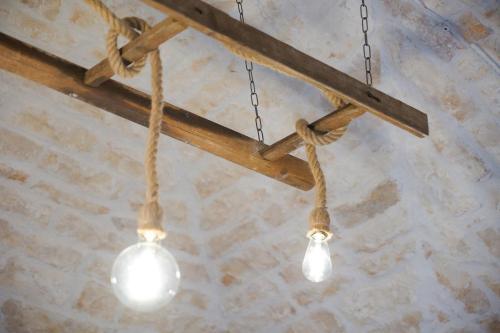 a couple of lights hanging from a wooden beam at Abba21 in Ostuni