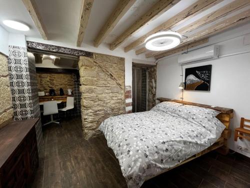 um quarto com uma cama e uma parede de pedra em Paella flat old town Alicante em Alicante