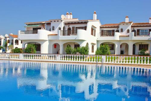 a large white house with a swimming pool at Apartamento Menorca SON BOU 53 by Mauter Villas in Son Bou