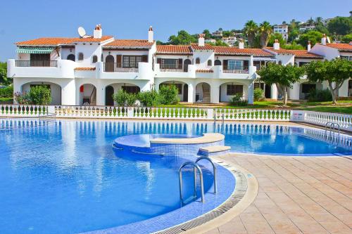 une grande piscine en face d'une maison dans l'établissement Apartamento Menorca SON BOU 53 by Mauter Villas, à Son Bou