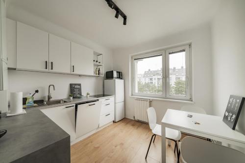 een keuken met witte kasten en een tafel en een raam bij Homely apartment - 10 minutes to Stephansplatz in Wenen